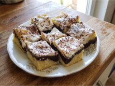 Babka zygzak z budyniem i śmietaną: Wilgotny deser z prostą dekoracją Babka zygzak z budyniem i śmietaną na blasze, udekorowana startą gorzką czekoladą