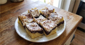 Babka zygzak z budyniem i śmietaną: Wilgotny deser z prostą dekoracją Babka zygzak z budyniem i śmietaną na blasze, udekorowana startą gorzką czekoladą