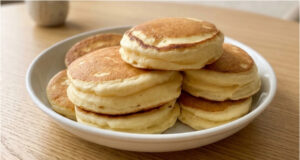 Przepis na wyjątkowo puszyste japońskie pancakes: Wysokie, delikatne i lekkie jak chmurka Puszyste japońskie pancakes na talerzu z syropem klonowym i owocami